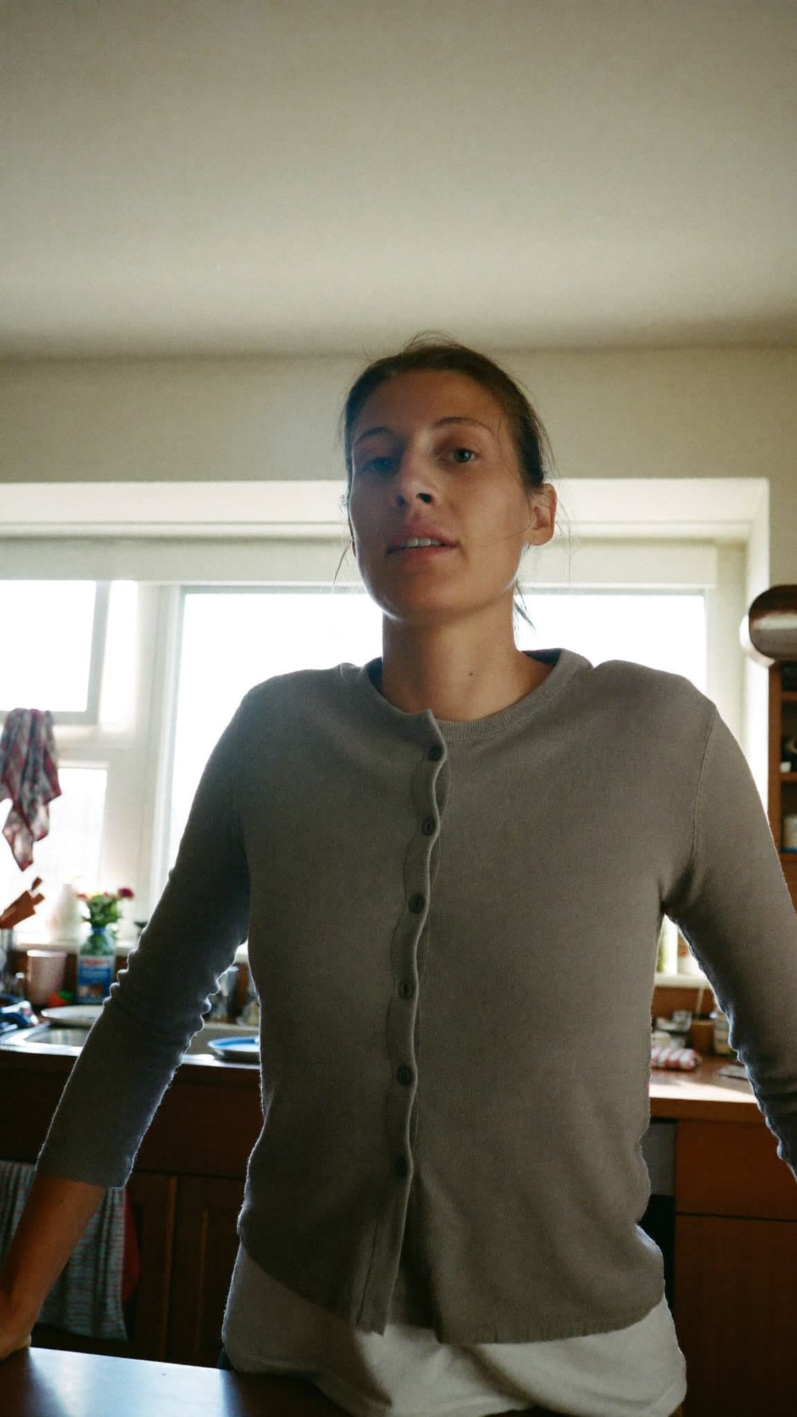 Prueba descartada: una mujer en una cocina en penumbra, con luz plana.
