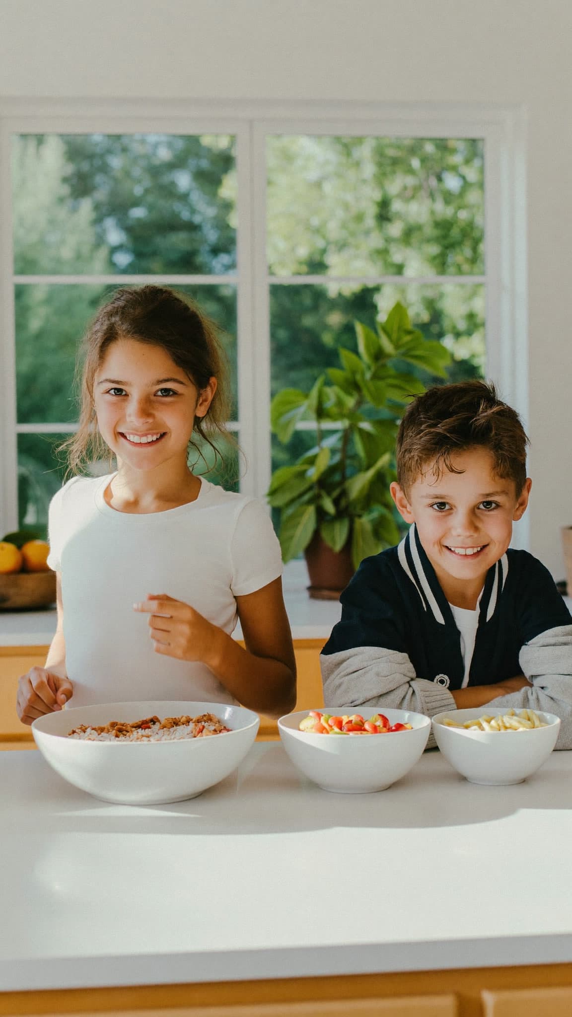 Imagen aprobada: una niña y un niño ante tres boles blancos en una cocina luminosa.