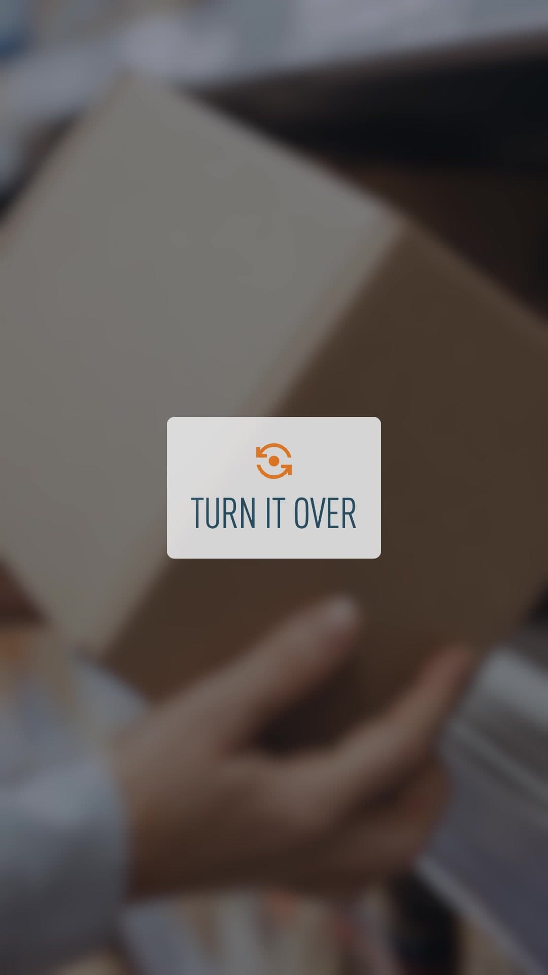 Unas manos sostienen una caja, con el rótulo “Turn it over”.